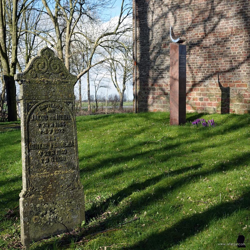 nogmaals een oud en een nieuw grafmonument naast de toren