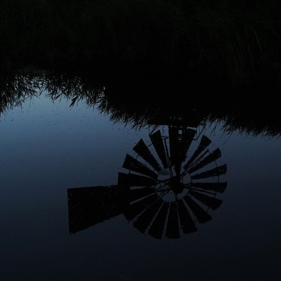 weerspiegeling van de bladen van de windmotor bij nacht