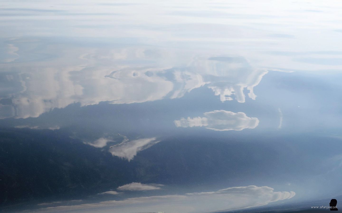 weerspiegelde wolken op een zacht golvende waterspiegel