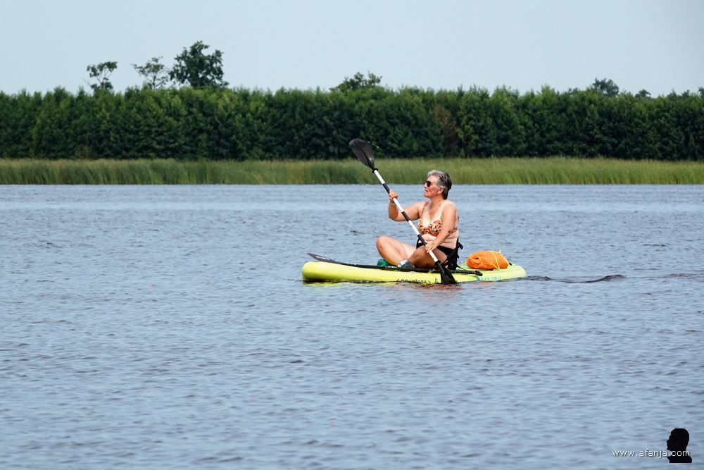 een vrouw peddelt rustig voort op een supplank