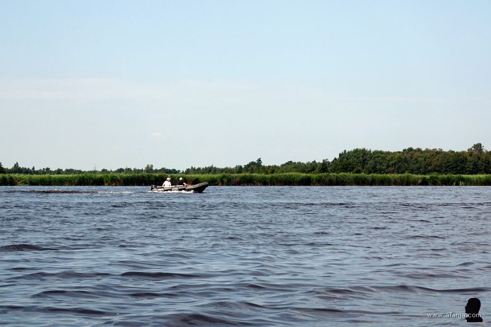 een klein bootje met buitenboordmotor vaart ons voorbij