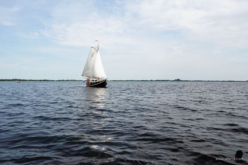 een mooie houten zeilboot draait achter ons langs