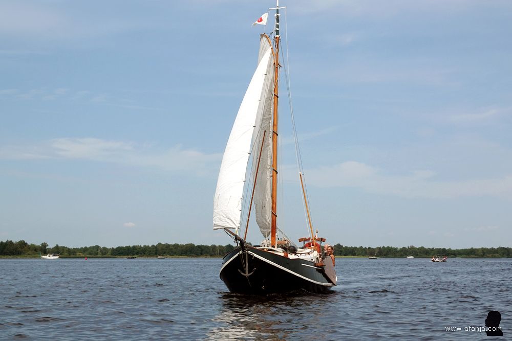 een mooie houten zeilboot draait achter ons langs