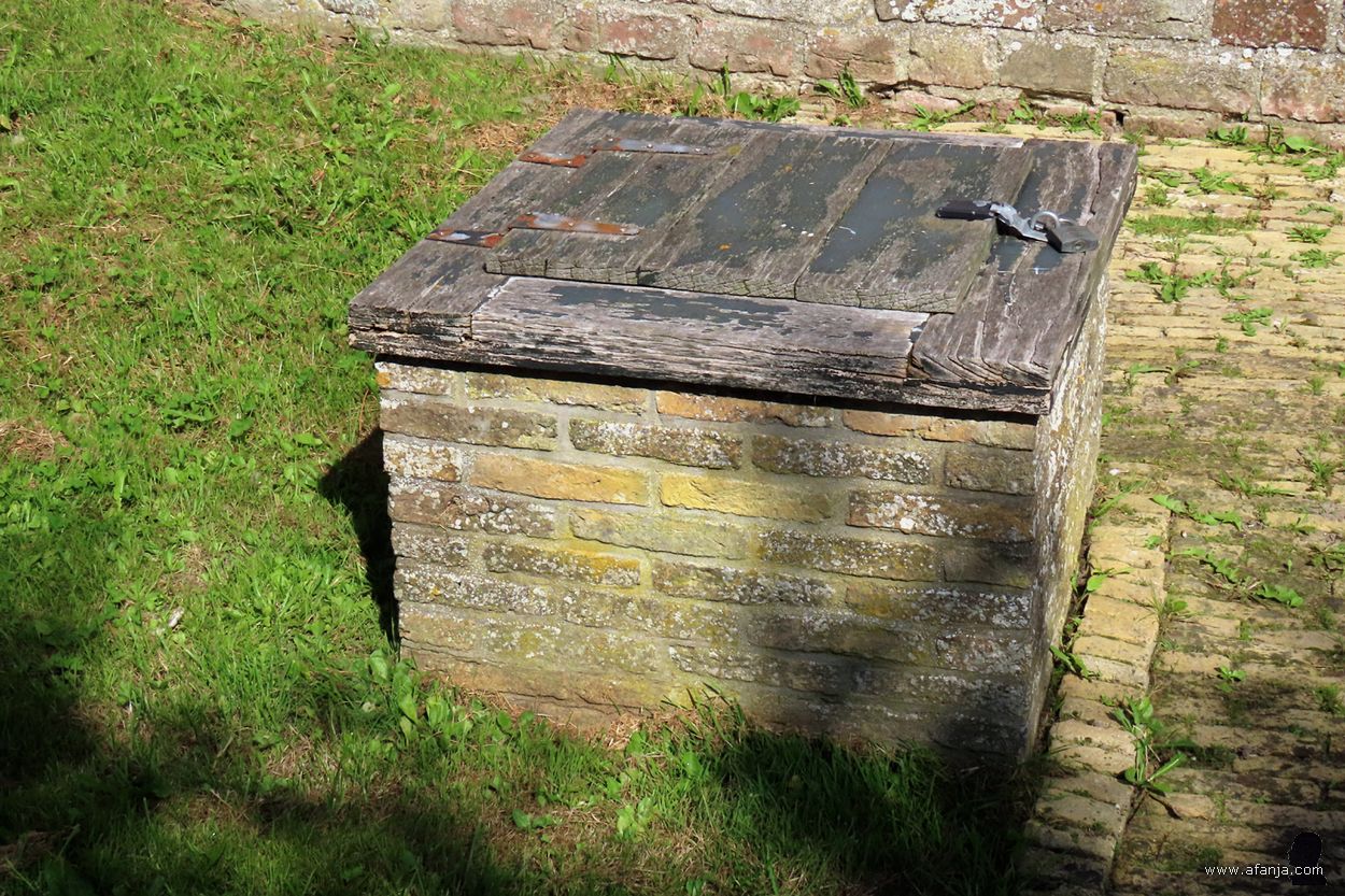 een vierkante waterput met een verveloos deksel