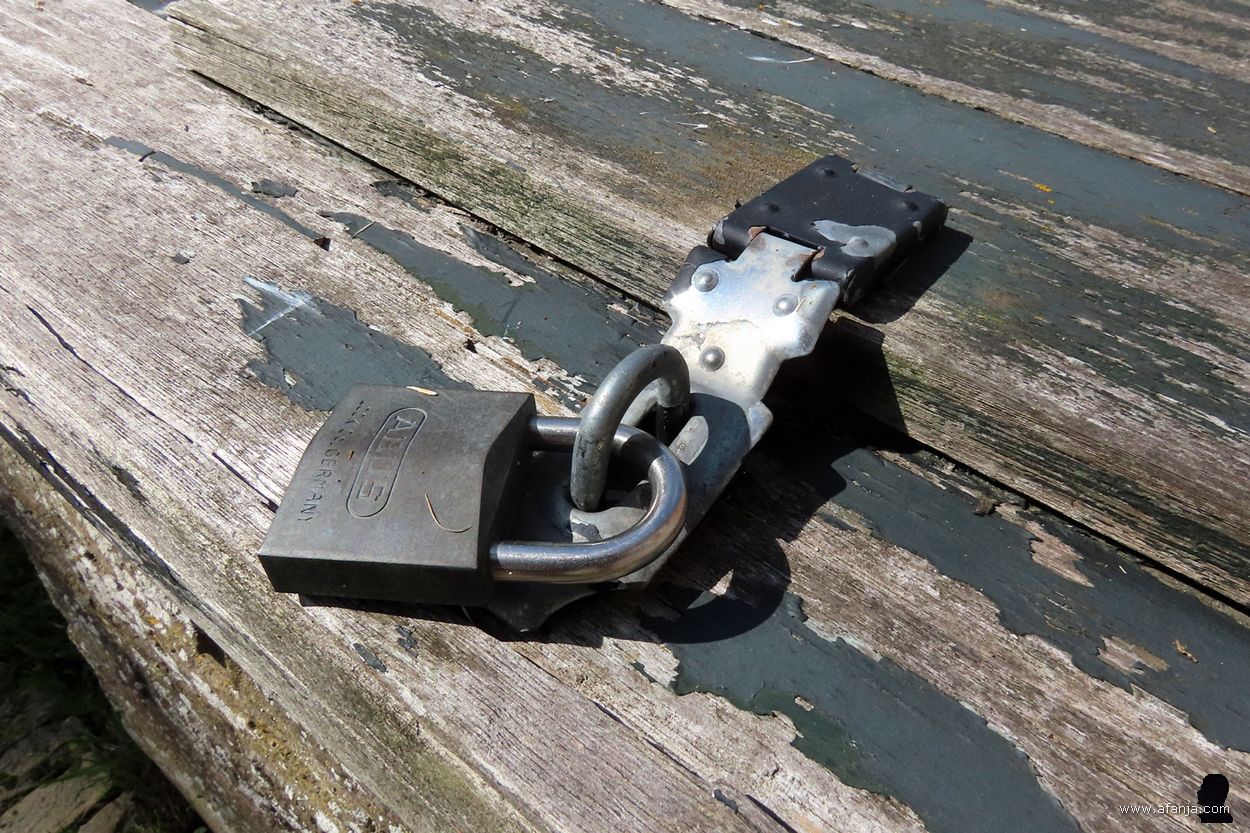 close-up van het hangslot op het verveloze deksel van de put