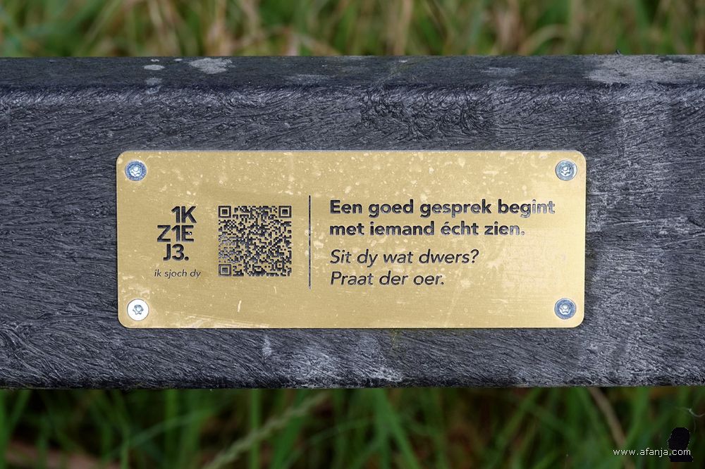 een bordje op een bankje met een QR-code