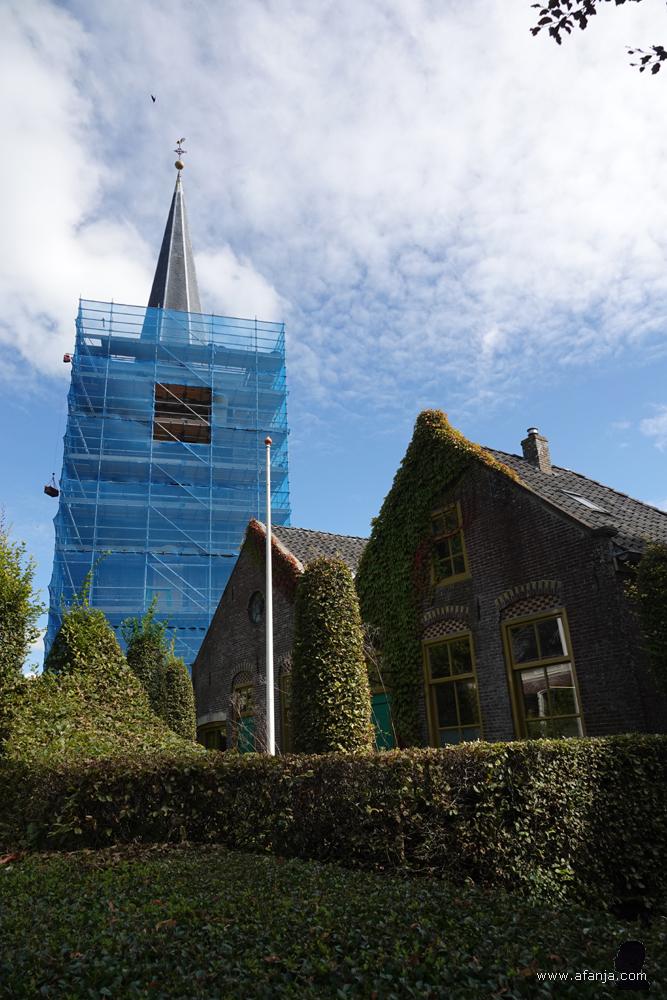 twee huizen en de kerktoren van Mantgum in de steigers