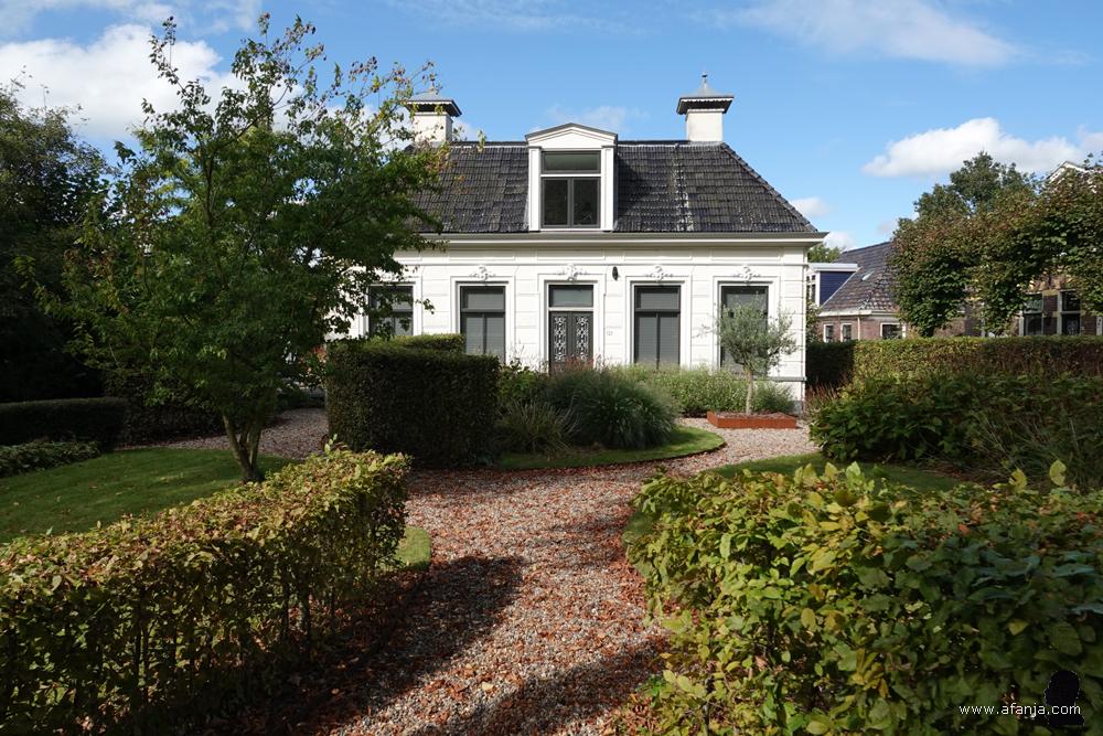 een mooi wit huis met een grote voortuin