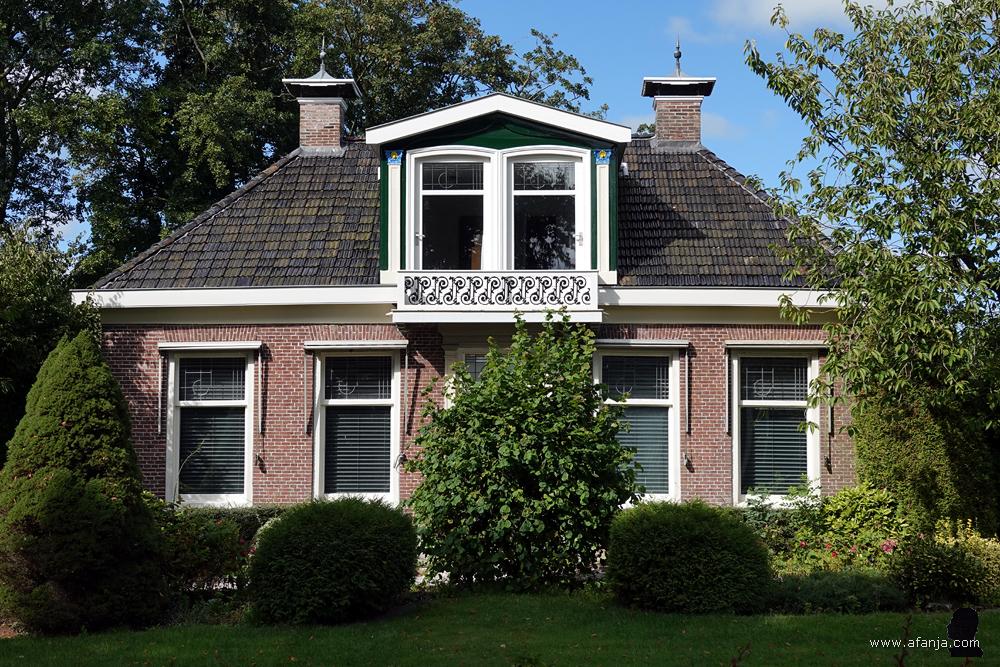 een huis met sierlijk smeedwerk op de eerste verdieping
