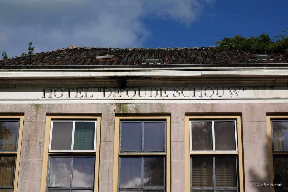 een haveloze gevel met de tekst Hotel 'de Oude Schouw'