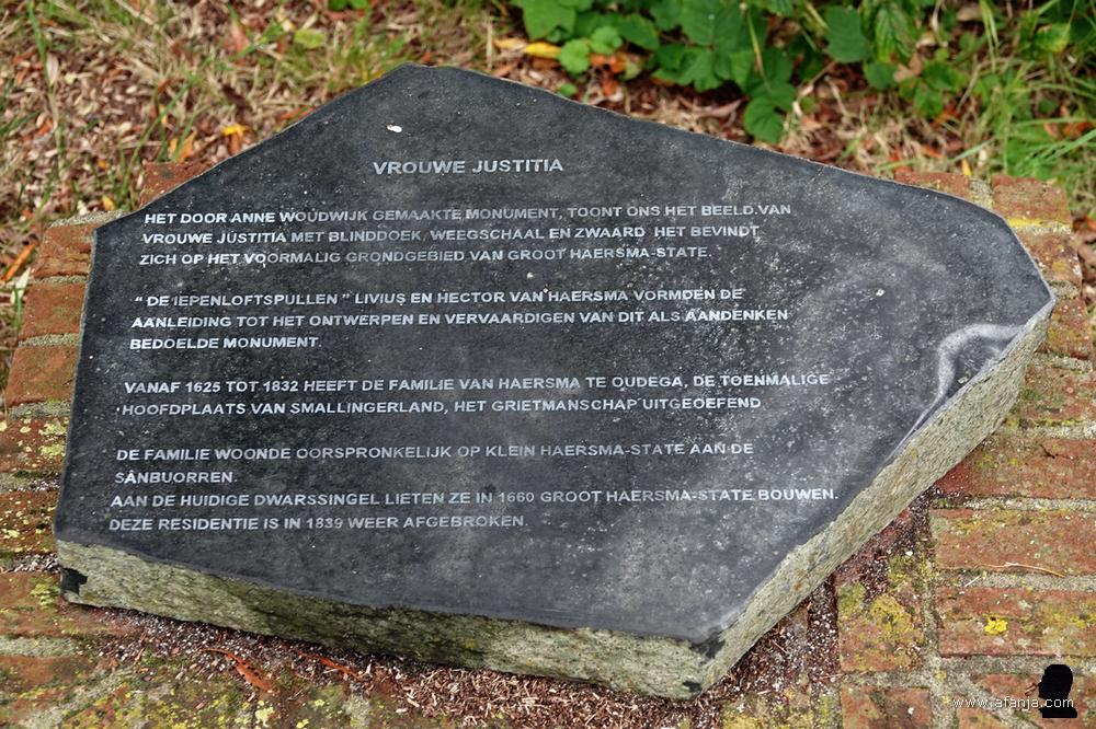 een platte steen met uitleg over 'Vrouwe Justitia'