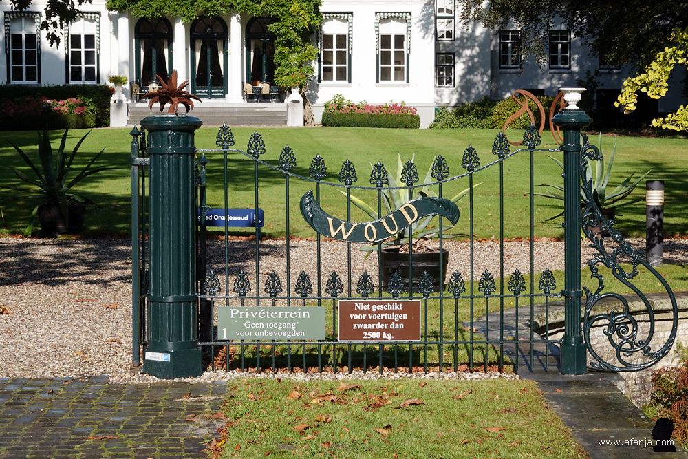 hekwerk rechts van de ingang met de letters 'woud'