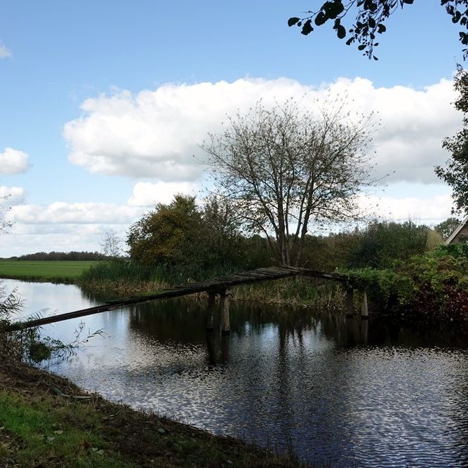 een woonboerderij met een gammel bruggetje over het Stroomkanaal bij Gersloot