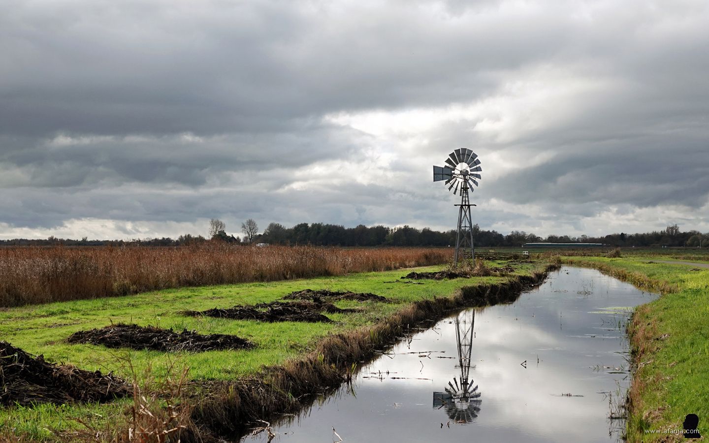 windmotor met weerspiegeling tegen een bewolkte lucht