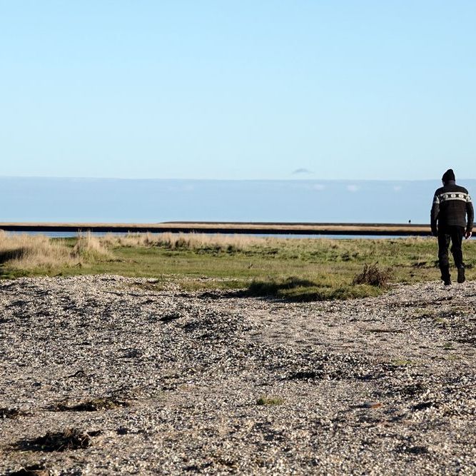 links in beeld twee vogelaars, rechts een passerende wandelaar