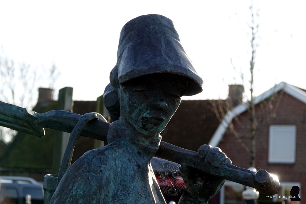 close-up van het beeld ‘de wjirmdolster’- de pierensteekster bij de Mariatsjerke in Wierum