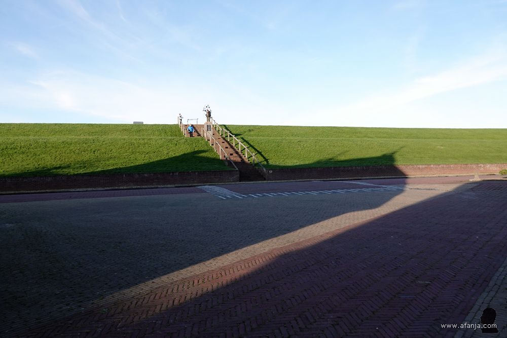 In de verte staat Jetske in haar blauwe jas bij het monument