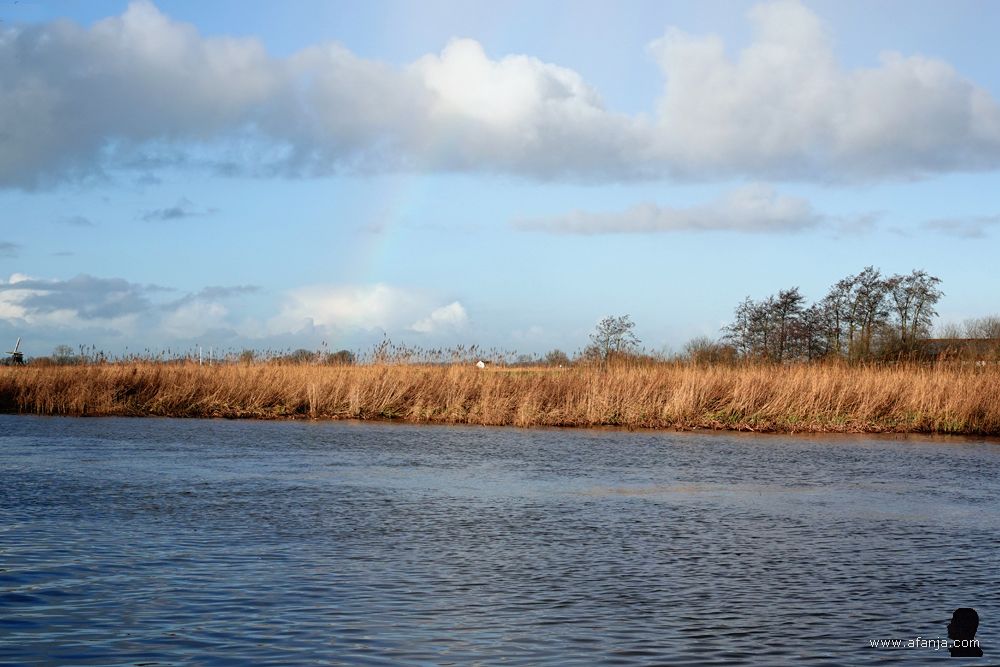 een beginnende regenboog tekent zich af boven It Eilân