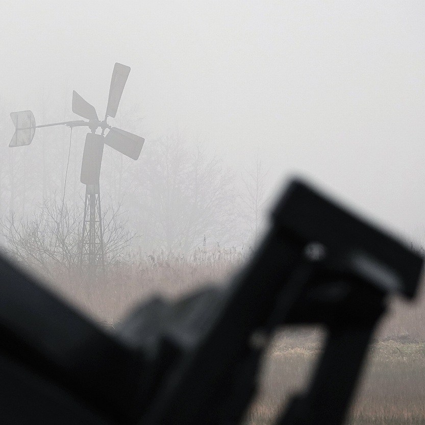 in de verte een kleine windmotor in de mist