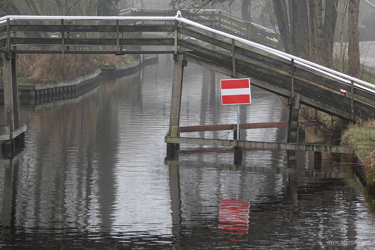 een bruggetje met een rood met wit bord 'verboden in te varen'