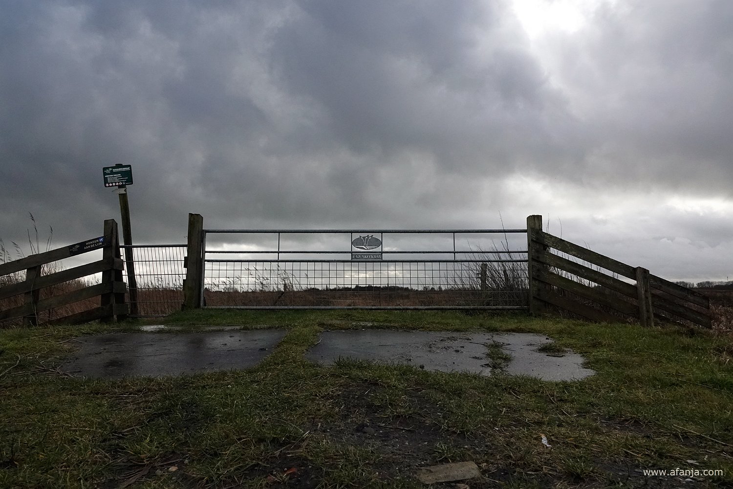 een hek in de Jan Durkspolder onder dreigende wolken