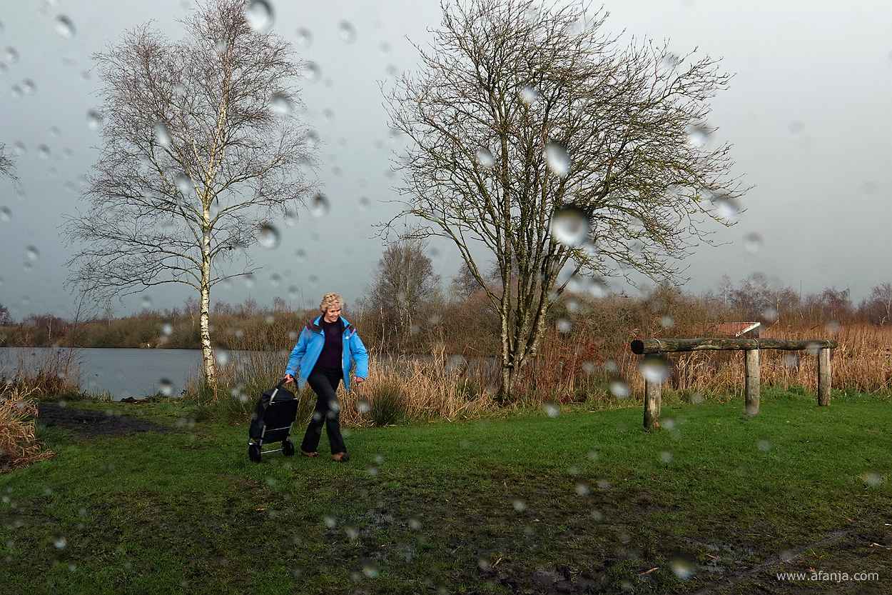 fotomaatje komt lachend teug naar de auto met haar fototas op wieltjes