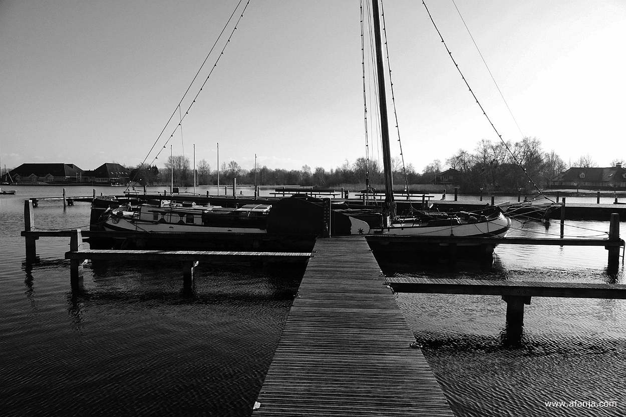 er ligt een skûtsje aan het eind van een aanlegsteiger in de jachthaven