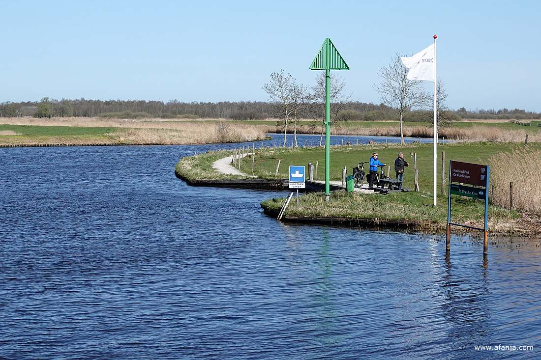 vanuit de richting Drachten staan een paar fietsers op het pontje te wachten