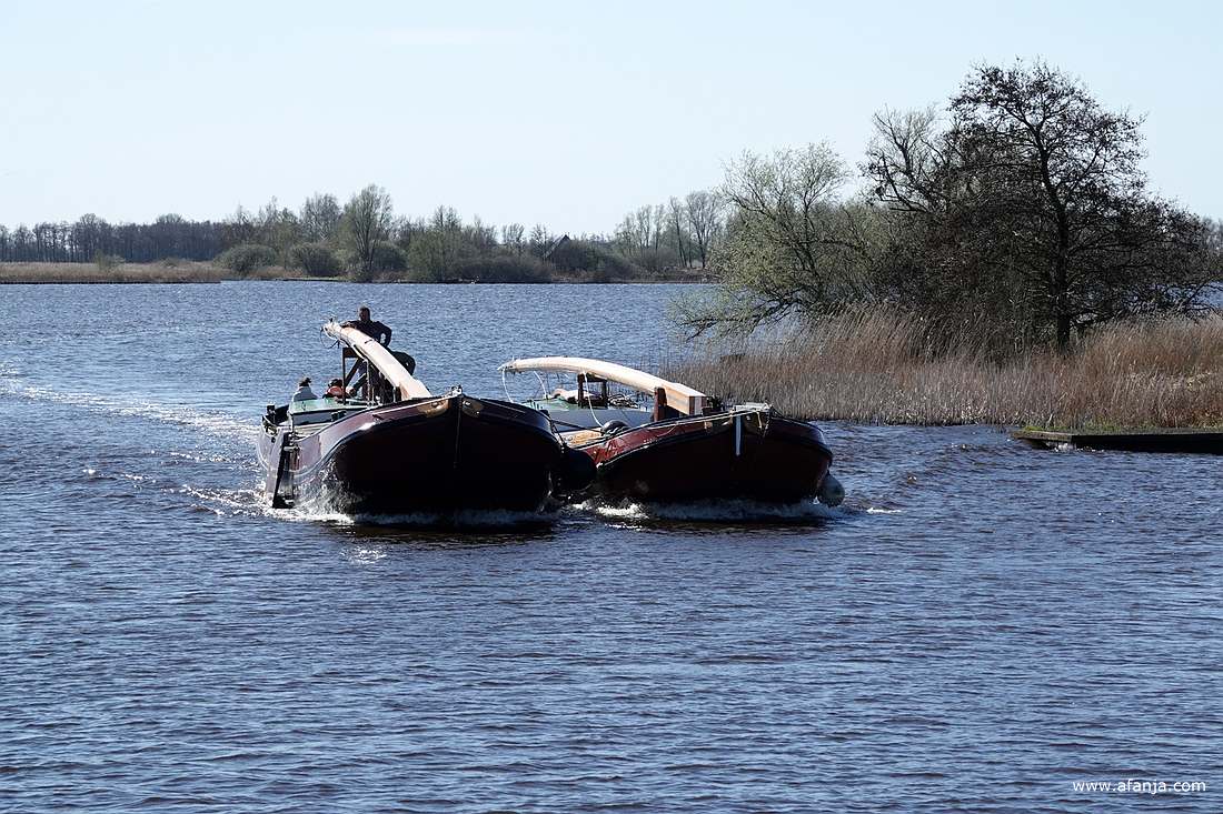 twee aan elkaar gekoppelde skûtsjes naderen ons van achteren