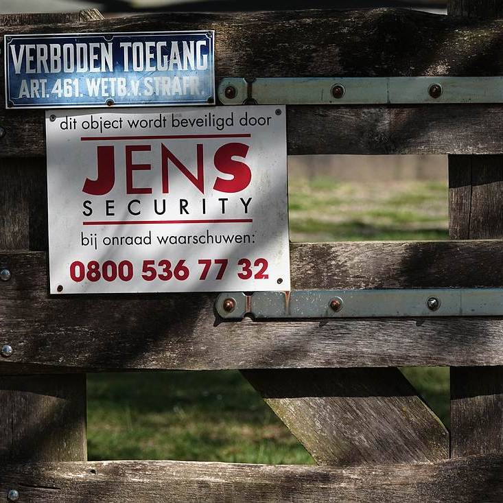 een hek met waarschuwingsborden