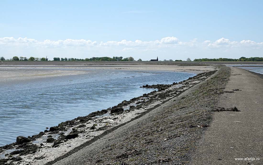 in het water links van de dam is centraal in beeld een wit stipje te zien