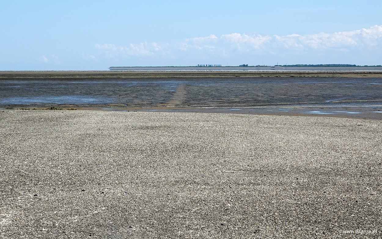 de Peazemerlânnen met in de verte de R.J. Cleveringsluizen, die de Waddenzee en het Lauwersmeer scheiden