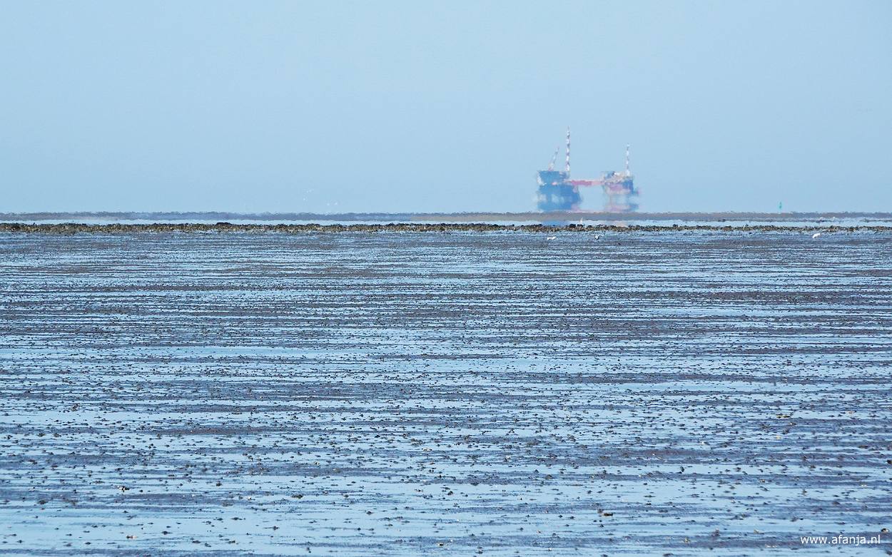 een fata morgana oftewel luchtspiegeling van een boorplatform aan de horizon