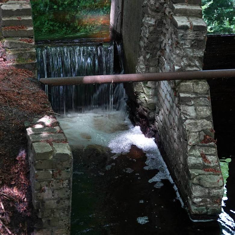 stromend water bij een kleine, deels geopende stuw
