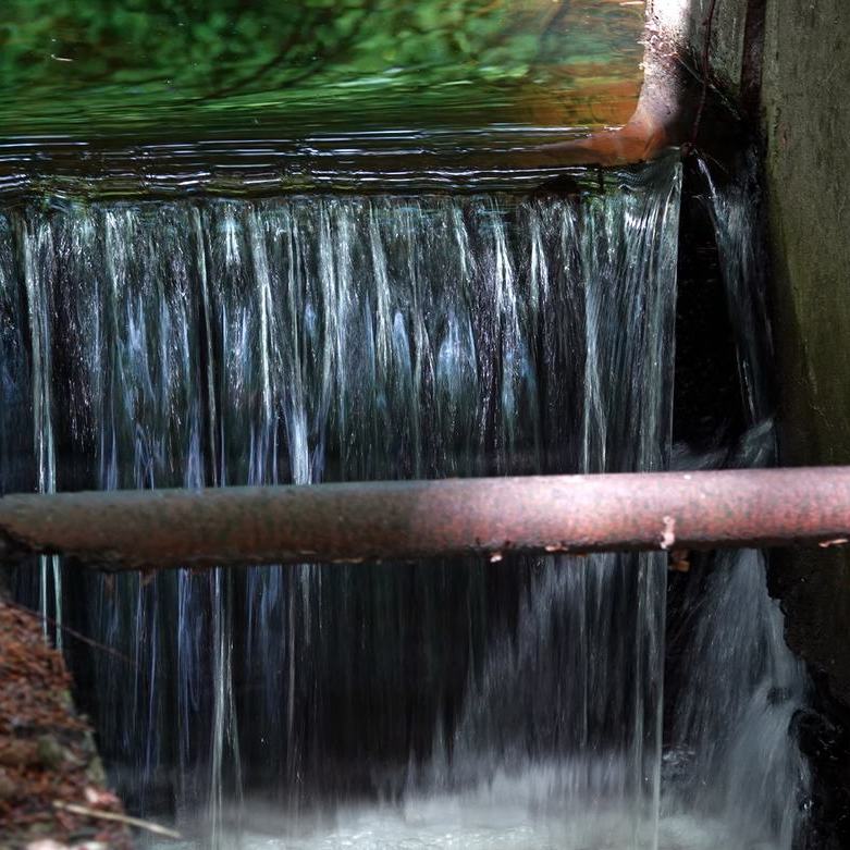 stromend water bij een kleine, deels geopende stuw