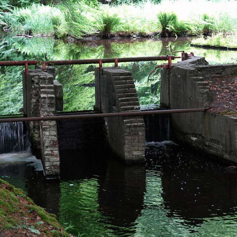 stromend water bij een kleine, deels geopende stuw