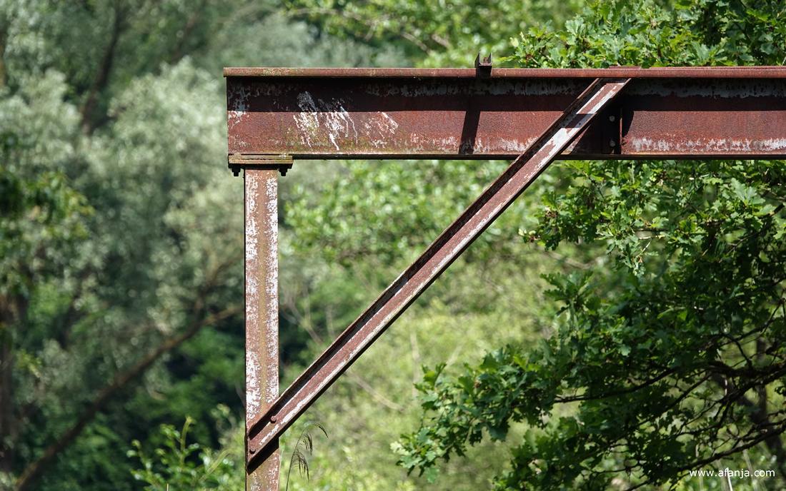 een paar roestige balken te midden van het groen
