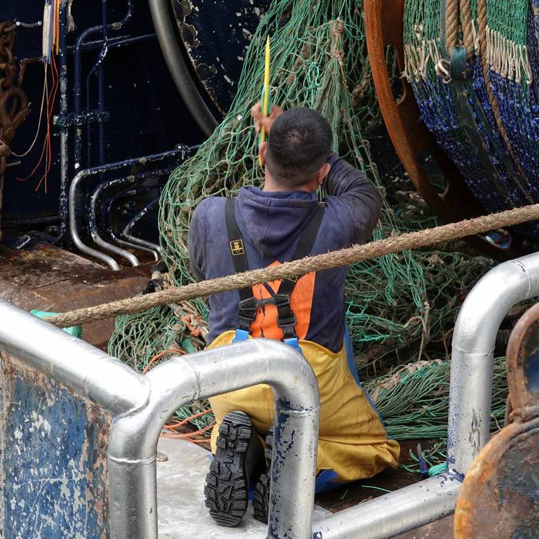 een visser is netten aan het boeten