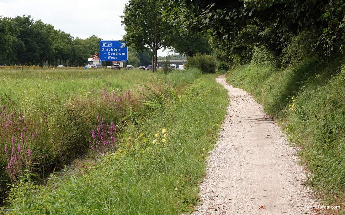 een schelpenpaadje naast de snelweg