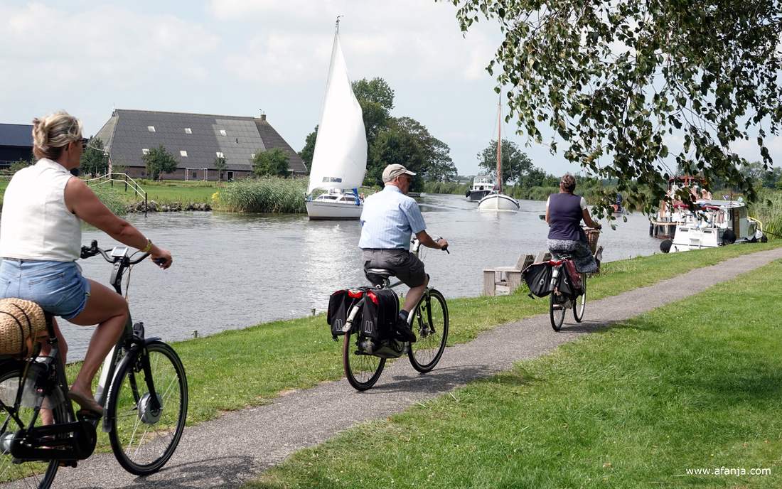 fietsers langs de Dokkumer Ee, boten in de Dokkumer Ee