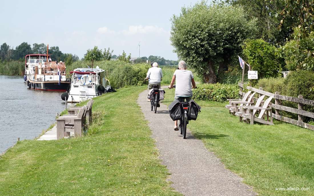 fietsers langs de Dokkumer Ee, boten in de Dokkumer Ee
