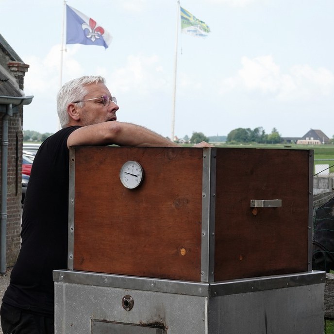 even over het randje kijken om de palingen netjes op te hangen in de rookoven