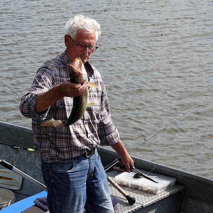 een van de vissers showt de ruim een halve meter lange snoek