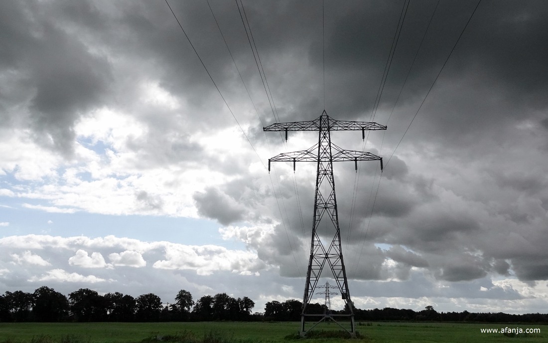 hoogspanningsmasten onder een donker wolkendek