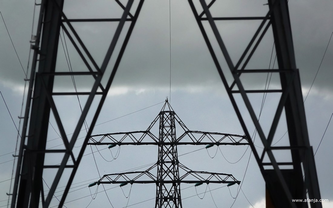 hoogspanningsmasten onder een donker wolkendek