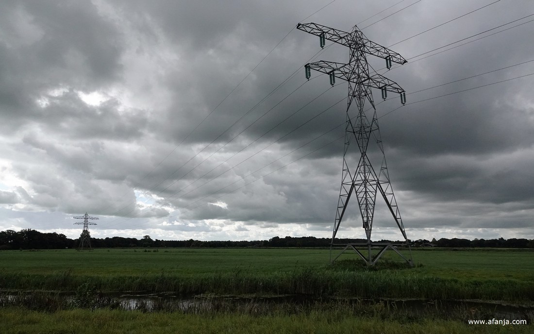 hoogspanningsmasten onder een donker wolkendek