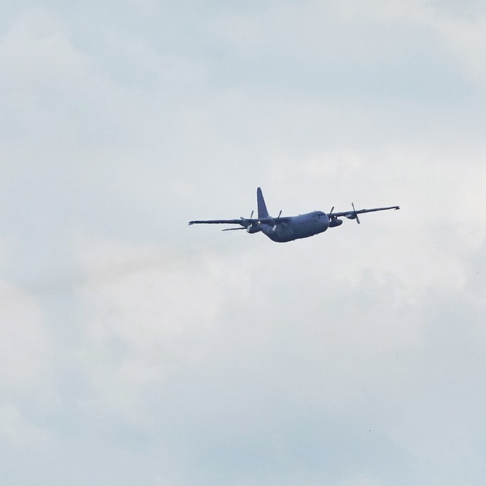 een laag overvliegend militair vrachtvliegtuig tijdens de oefening 'Falcon Leap' boven de Leijen