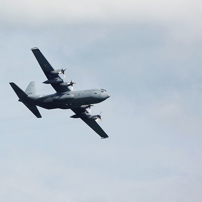 een laag overvliegend militair vrachtvliegtuig tijdens de oefening 'Falcon Leap' boven de Leijen
