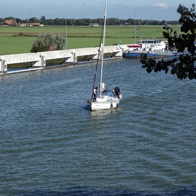 een zeilboot nadert de brug