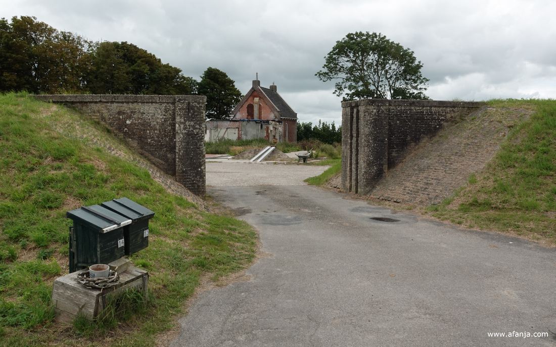 een afgebroken boerderij achter een dijkcoupure in de oude zeedijk